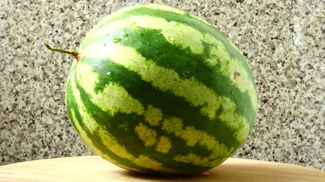 Watermelon on a kitchen board.	Shooting in the movement.