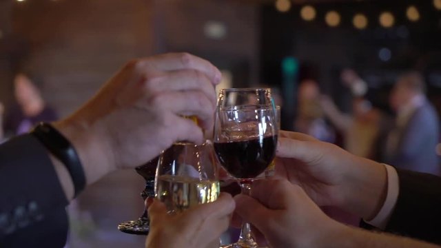 People clink glasses with wine and champagne after toast at the celebration wedding party