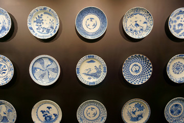 Decorative blue and white ceramic plates on the dark wall    