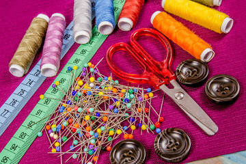 Supplies and accessories for sewing - scissors, threads, pins, buttons, centimeter.