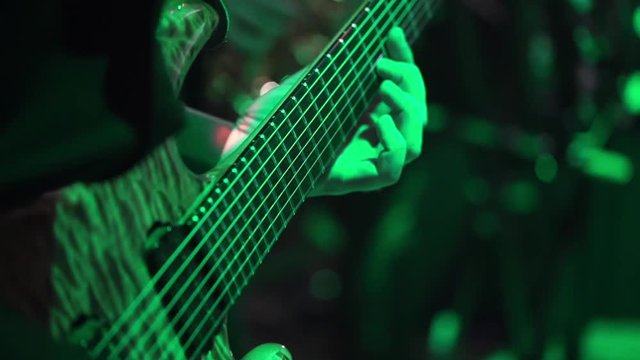 Guitarist on stage playing guitar at the concert