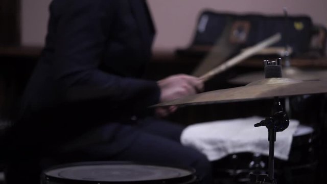 Man plays musical percussion instrument with sticks closeup on a concert stage, a musical concept with the working drum close up