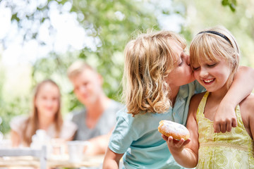Junge küsst liebevoll seine Schwester
