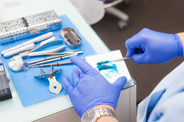 An orthopedist dentist prepares a polymer material for making a dental working model.