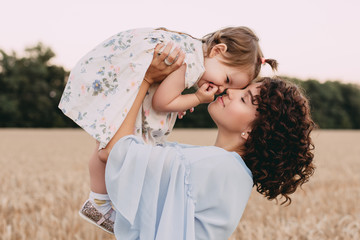 Mother and daughter in a wheat field, family portrait