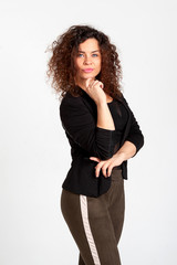 Beautiful woman with dazzling open smile and lush hairdo in afro style posing on white background. The woman is dressed eclectically in khaki leggings and a shortened jacket.