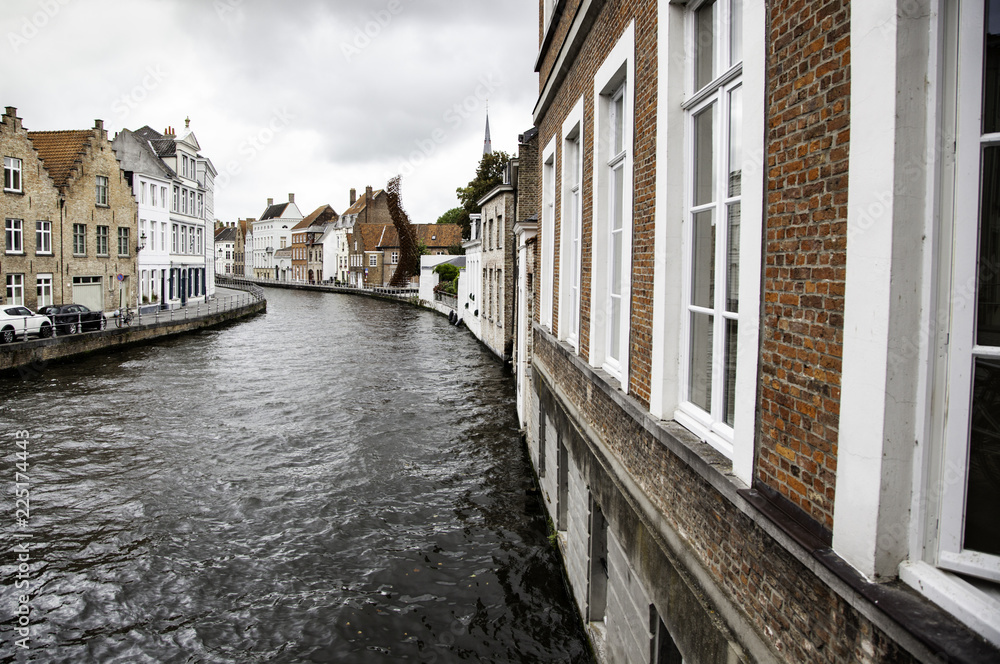 Wall mural BRUGES, BELGIUM - SEPTEMBER 05, 2018: Canal in Bruges and famous Belfry tower on the background in a beautiful autumn day, Belgium on September 05, 2018