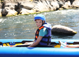 Little boy kayaking on river. Summer camp