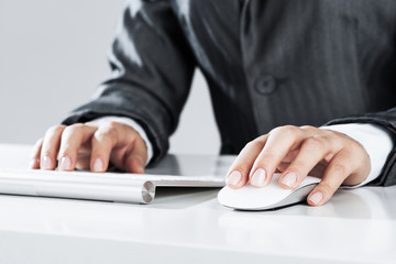 Closeup of businesswoman hand typing on keyboard with mouse on w