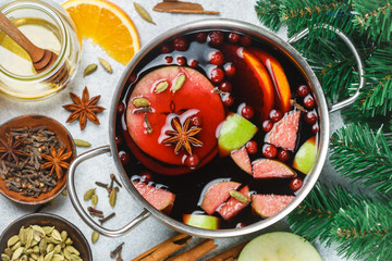 Fototapeta na wymiar Mulled wine is a traditional winter drink with red wine, honey, orange, green Apple, cranberry and spices - cinnamon, cardamom, star anise, cloves, ginger, pepper. grog. punch. Christmas. New year