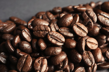 Roasted coffee beans on grey background, closeup