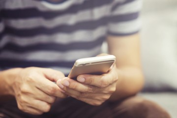 Young man Casual wear using on cell phone during rest in office. sitting sofa in watching message on mobile phone during break.