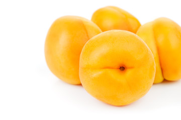 ripe juicy yellow apricots on a white table