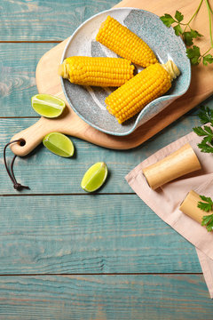Flat lay composition with corn cobs on wooden background with space for text