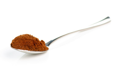 A spoon of ground coffee on a white background isolation