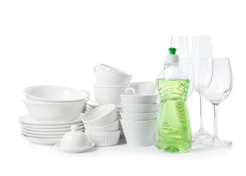 Clean tableware and bottle of detergent on white background. Washing dishes