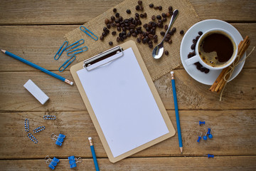 cup of coffee and notebook on wooden table with copy space for your text