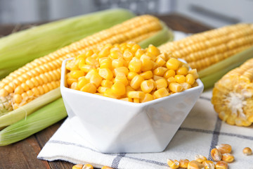 Bowl with corn kernels on wooden table