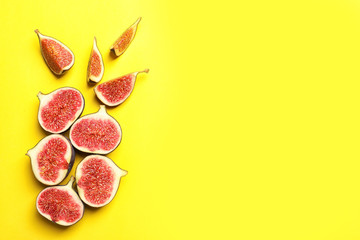 Cut ripe figs on color background, top view. Space for text