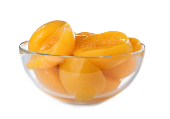 Fototapeta na wymiar Bowl with halves of canned peaches on white background