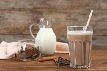 Glass of chocolate milk on wooden background. Space for text