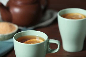 Cup of tea with lemon on table, closeup