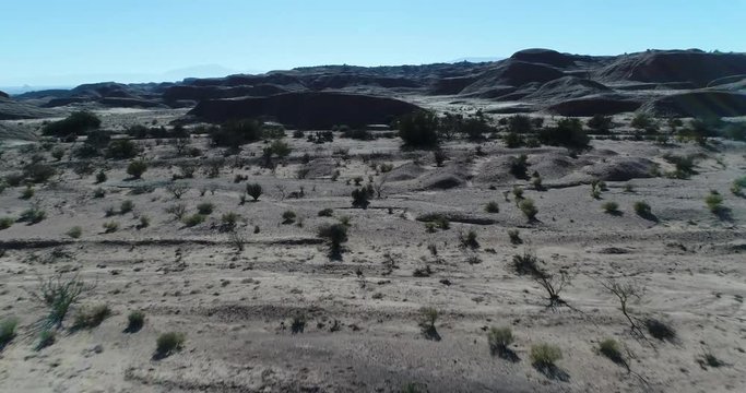 Aerial drone scene of geological formations, eroded sandrock mountains, gullies at National Park Talampaya, world natural heritage, La Rioja. Camera moving forwards and upwards discovering landscape.