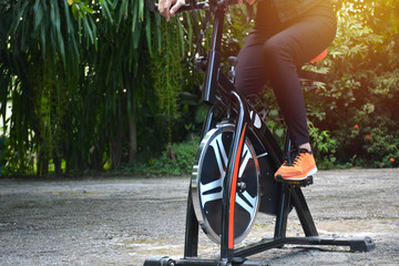 Female exercising on bicycle for exercising and healthy lifestyle concept.