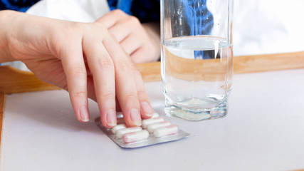 Closeup image of female hand holding pills in blister pack