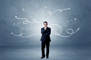 Elegant businessman choosing between directions with winding drawn arrows around 
