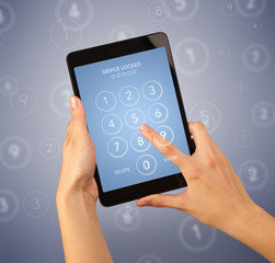 Female fingers touching tablet with locked device requiring passcode