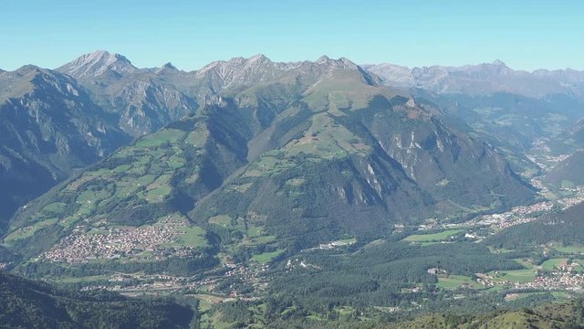 4K Drone aerial view to the Seriana valley and Orobie Alps in a clear and blue day. View of the highest mountains. Landscape from Pizzo Formico Mountain, Bergamo, Italy