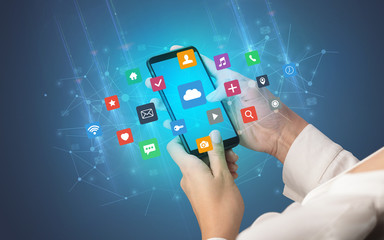 Female hand using smartphone with colorful application icons around