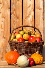 Wicker basket with apples and pears. Autumn harvest of fruit. Fresh fruit in a basket.