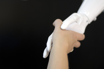 Shaking hands with a robot. A woman meets a robot .