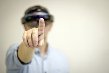 A man-businessman with a virtual reality headset controls his hand. Future technology.