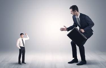 Big debutant young businessman scared of small strong businessman
