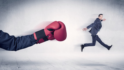 Huge Boxing Gloves punches innocent businessman concept
