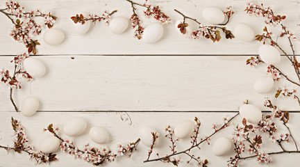 Happy easter. Easter decoration - Easter eggs and flowering branches on a white wooden background.