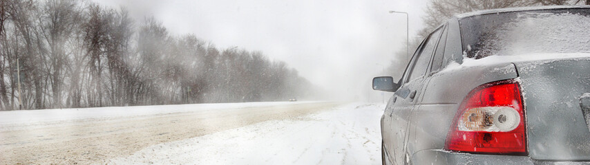 Car on winter road in a snowstorm and bad visibility, border design panoramic banner 