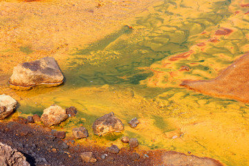 Fototapeta na wymiar yellow water in a shallow river poisoned by copper production