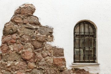 Window with bars on white wall. The wall of old house.