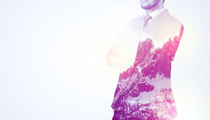  Young businessman in suit standing with sunny snowy mountain and trees graphic.