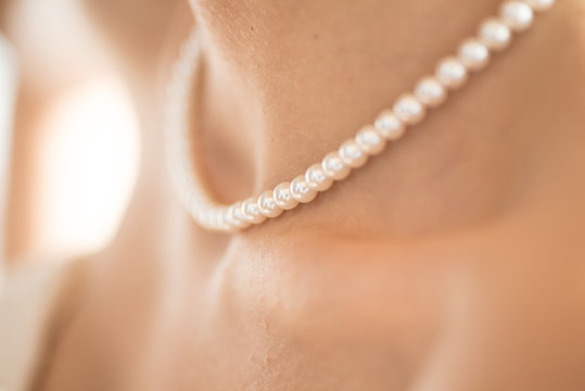 Junge Frau trägt Perlenhalskette