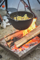 preparing stew in the cauldron at the stake
