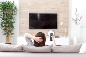 Young woman watching TV in the room