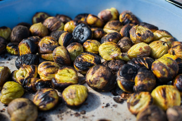Grilled baked roasted chestnuts zoom view, closeup view in a pan
