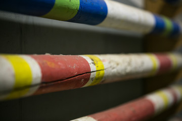 Stack of equestrian jumping poles in various colors