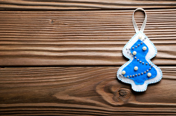 Handmade rustic felt Christmas tree decorations on wooden table