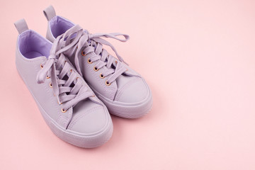 Fashion blog or magazine concept. Pink female sneakers over pastel pink background. Flat lay, top view